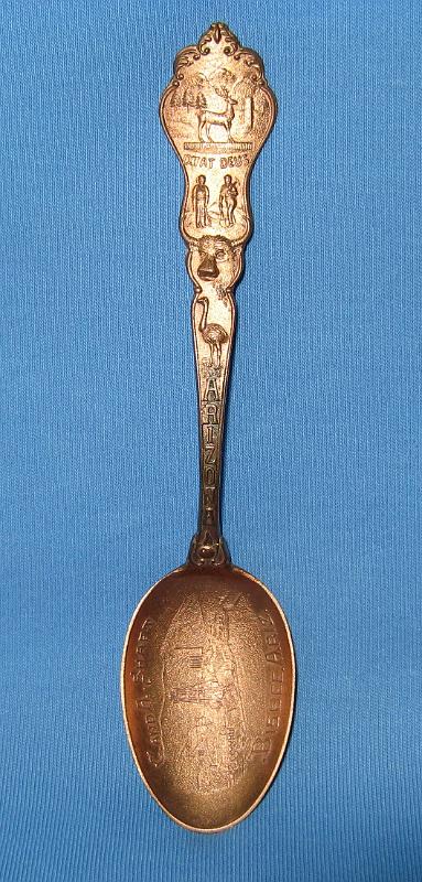 C & A Shaft Bisbee, AZ.JPG - SOUVENIR MINING SPOON C & A SHAFT BISBEE ARIZONA - Copper souvenir spoon, circa 1900, embossed mining scene in bowl with C. and A. Shaft above and Bisbee, Ariz. below, handle finial with Arizona territorial seal and ARIZONA on the handle, fancy design on handle reverse, 5 1/4 in. long [Although Phelps Dodge, owner and operator of the famous Copper Queen mine, was the largest mining company in Bisbee, Arizona it was not the only one. The Calumet and Arizona (C&A) Mining Company, organized in March 1901 with Charles Briggs as president, operated several large and profitable mines, principal among them the Irish Mag mine, adjacent to the Copper Queen.  By 1907, the C&A was the fourth-most productive copper mine in Arizona, and ran its own smelter in Douglas, Arizona. In 1911, the company merged with the Superior and Pittsburg Copper Company ultimately buying out Superior and Pittsburg in 1915.  The original C&A mine included 12 claims and 178 patented acres adjoining the Copper Queen.  With John C. Greenway as general manager, the company expanded operations to include the Irish Mag shaft to a depth of 1350 feet, the Ontario shaft to a depth of 1450 feet, the Powell shaft to 600 feet deep, the Hoatson shaft to 1530 feet deep and the Junction shaft to 1837 feet deep.  By 1910 the C&A employed 1274 men, 805 at the mine and 469 at the smelter.  In 1915 copper production exceeded 65 million pounds and by 1916, the company controlled over 2000 acres of mining property within the Warren Mining District.  The C&A was the first mine in Arizona to discontinue work on Sundays effective August 1910. The company’s fortunes took a turn for the worse in the 1920s and with the company failing, Phelps Dodge bought out their old nemesis in September 1931.]  